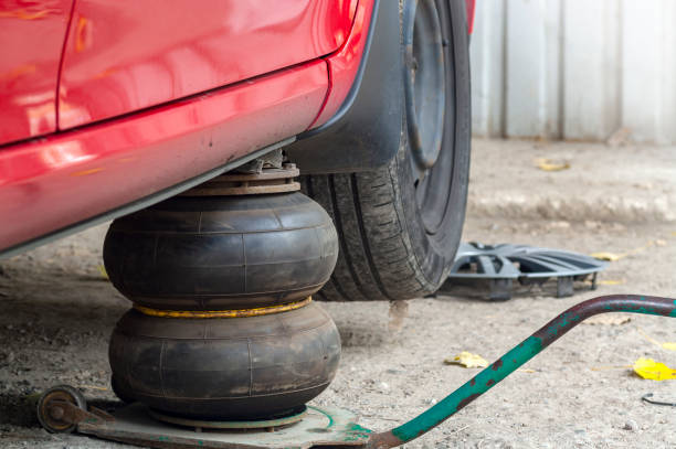 istock Replacing wheels on a car, pneumatic jack holds the body. 1175771148