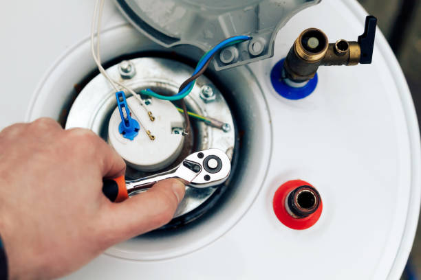 the worker has finished servicing the boiler and tightens the last nuts.close up