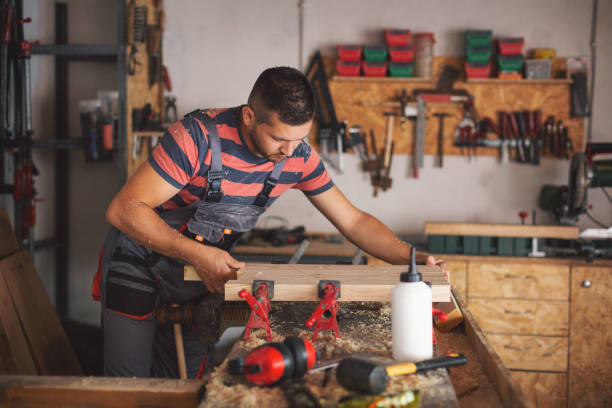 istock Young carpenter gluing wood 1175782153
