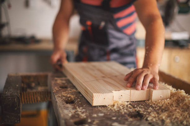 istock Young carpenter gluing wood 1175782424