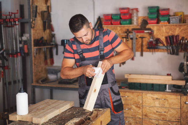 istock Young carpenter gluing wood 1175782477