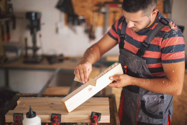 istock Young carpenter gluing wood 1175782591