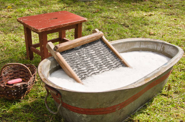 An old fashioned washing trougth filled with water, a vintage washboard and soap that wash the laundry stock photo