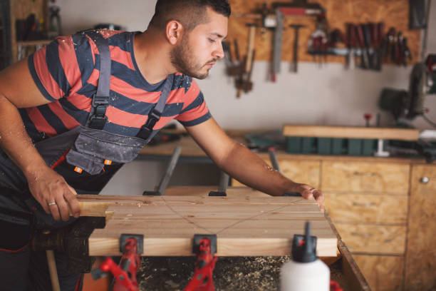 istock Young carpenter gluing wood 1175783137