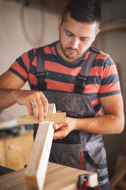 istock Young carpenter gluing wood 1175783184