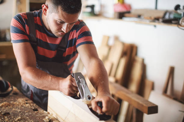 istock Young carpenter plaining wooden table 1175783462