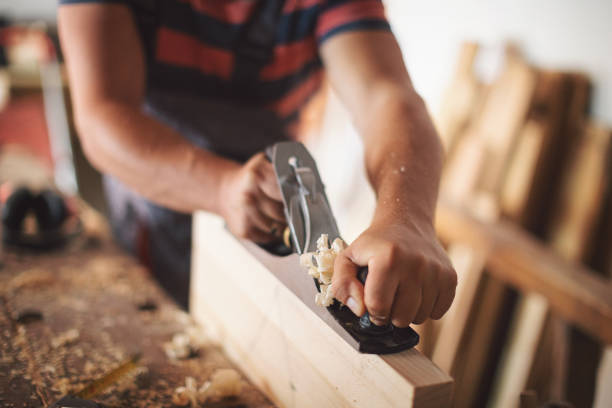 istock Young carpenter plaining wooden table 1175783479