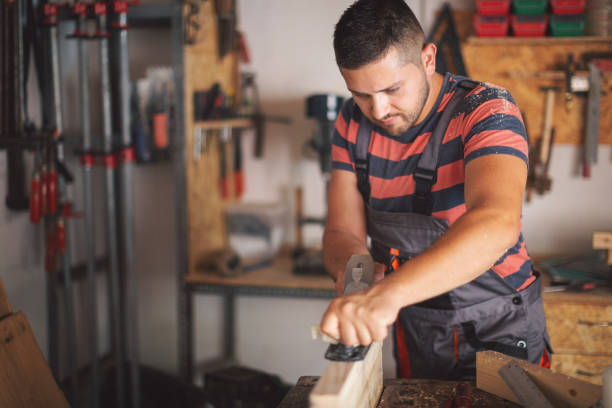 istock Young carpenter plaining wooden table 1175783537