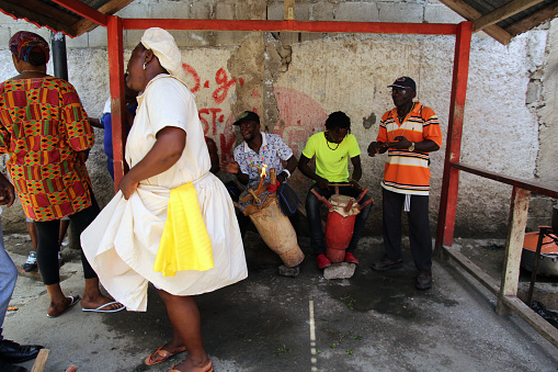 Plaine-du-Nord, Haiti - Aug. 22, 2019:  A Voodoo priestess dances  under an awning in a small square. Plaine-du-Nord is a major center of the Voodoo religion, in which music and ritual dancing  are fundamental.