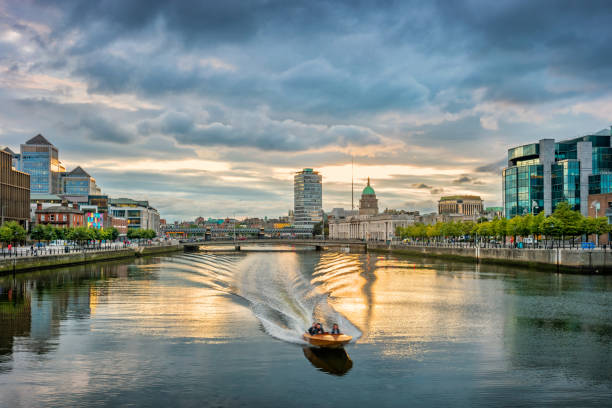 Motorboat speeding on River Liffey Dublin Ireland Stock photograph of a motorboat speeding on River Liffey in Dublin Ireland at sunset. dublin republic of ireland stock pictures, royalty-free photos & images