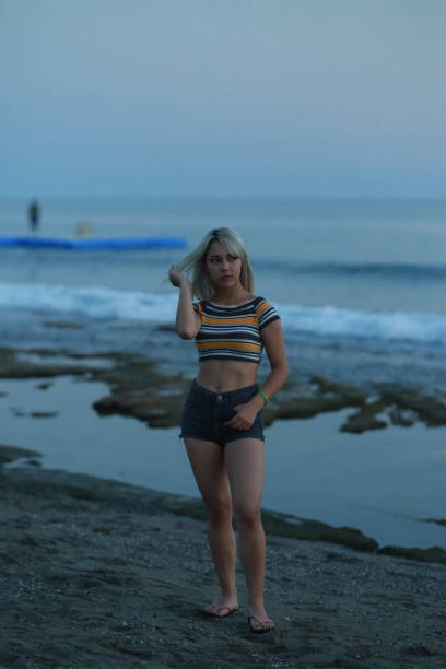 istock Beautiful model on the beach by the sea in sunset 1175787084