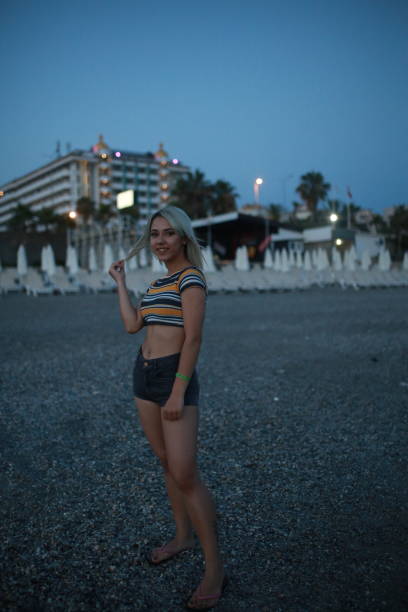 istock Beautiful model on the beach by the sea in sunset 1175787778