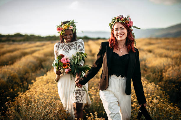 istock Two lesbian brides walking in the flower field 1175787971