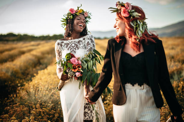 istock Two lesbian brides walking in the flower field 1175788032