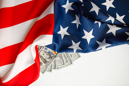 100 dollar bills lying on the stars of the American flag, close-up shot
