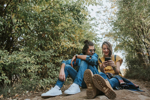 istock Young couple in park using phone 1175792028