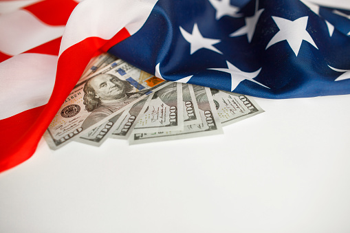 American Dollars Cash Money.  One hundred dollars banknotes close-up on  USA flag background