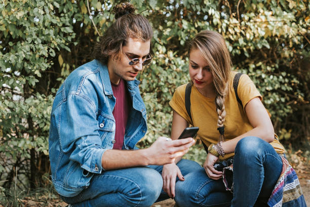 istock Young couple in park using phone 1175792057