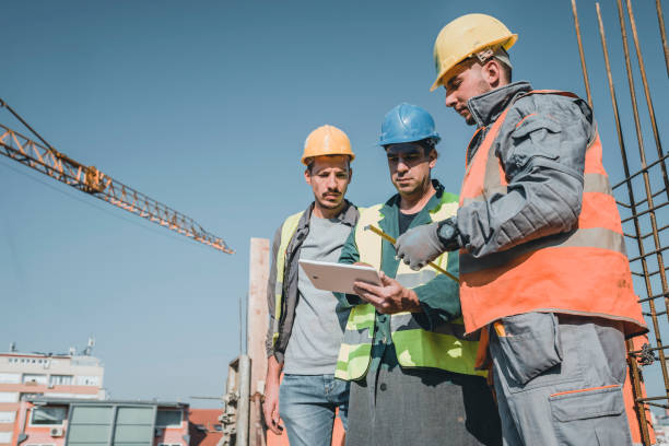 istock Experienced Construction Worker is Explaining Building Project to his Coworkers 1175794353