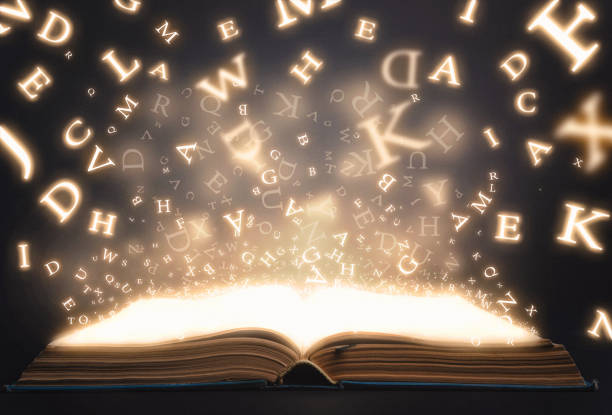 Old book open with flying magic letters stock photo