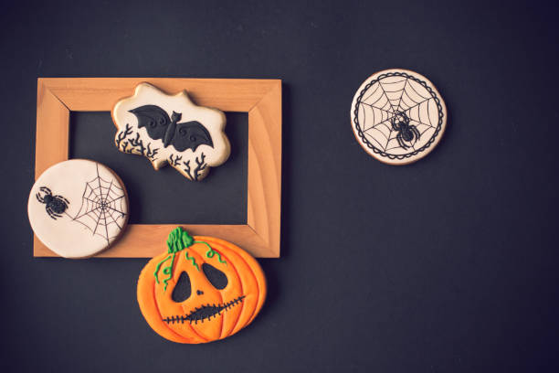 istock Halloween cookies and wooden frame on black background 1175802490