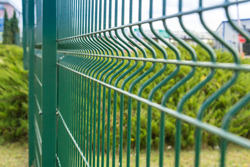 Close-up of the iron fence, green sectional steel fence. The concept of protection