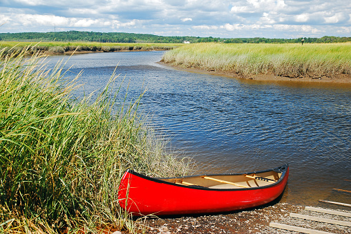 A canoe is ready for adventure along a small waterway