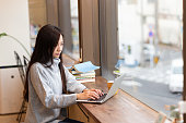 カフェでラップトップを見ている若い日本人女性