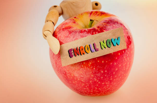 istock Enroll now wording written on blank torn paper on apple 1175822245