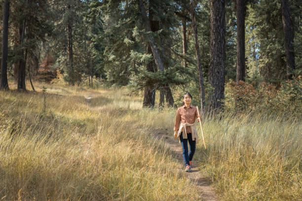 An asian woman enjoys a nice day hike at a trail near Coeur d'Alene, Idaho.