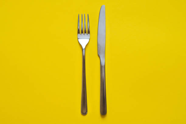istock Fork and knife isolated on yellow background 1175824525