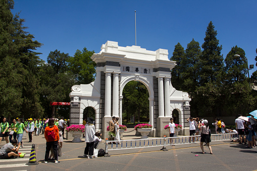 Beijing, China - June 29, 2019: Visitors having their pictures taken at the Memorial Gate, the vintage Tsinghua University arch.