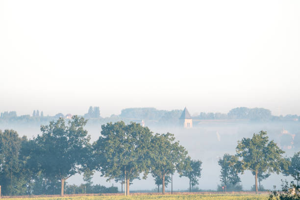 landscape on an early beautiful morning with some misty houses among the houses