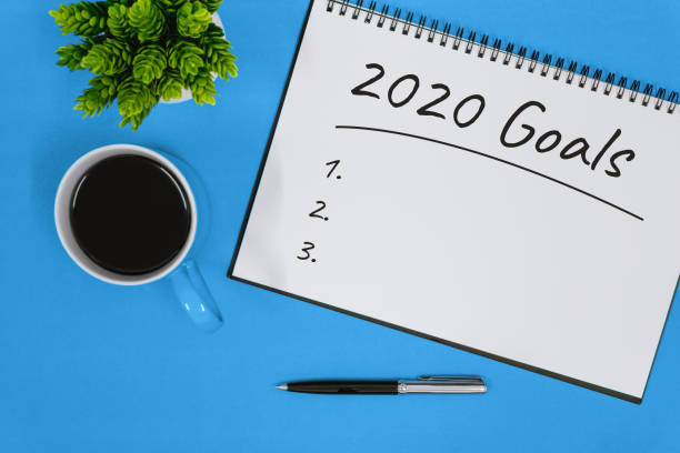 istock 2020 Goals. Notepad and Coffee Cup on Blue Background 1175837133
