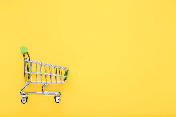 istock Small shopping cart on yellow background 1175838625