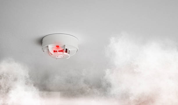 smoke alarm or smoke detector in home going off with thick smoke close-up of smoke alarm or smoke detector in home going off with thick smoke smoke detector photos stock pictures, royalty-free photos & images