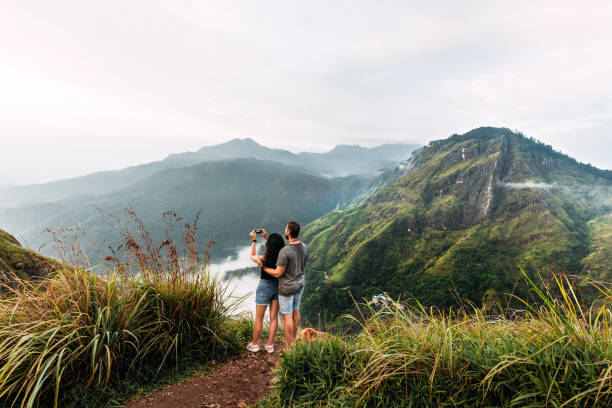 The couple travels the world. A couple in love travels to Sri Lanka. The couple travels to Asia. Man and woman meet the dawn in the mountains. Vacation in Asia. Happy couple in the mountains. stock photo
