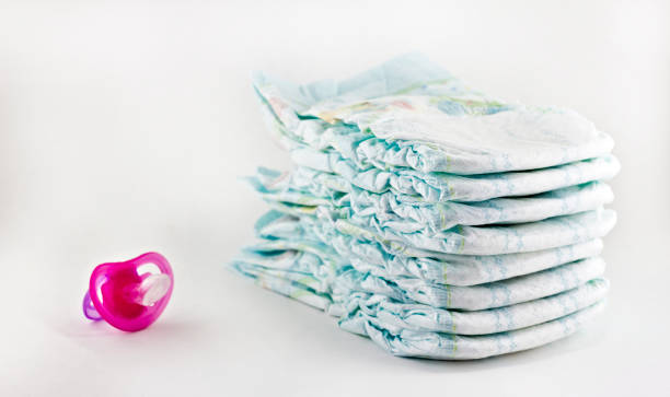istock Diapers and nipple on white background 1175842186