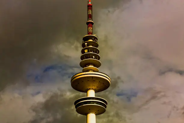 Hamburg TV Tower Against the backdrop of an autumn sky with clouds. image has too much noise, film grain, compression artifacts and or posterization results.
