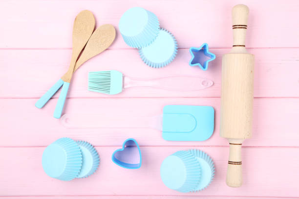 istock Cupcake cases with kitchen utensils on pink wooden table 1175847940