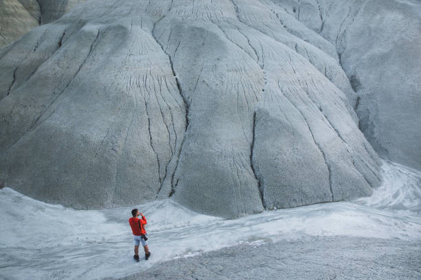 Scenic badlands, wind-sculpted sandstone formations on the hills of the canyon with desert plants growing in summer. Hoodoos trail, Drumheller, Alberta, Canada.