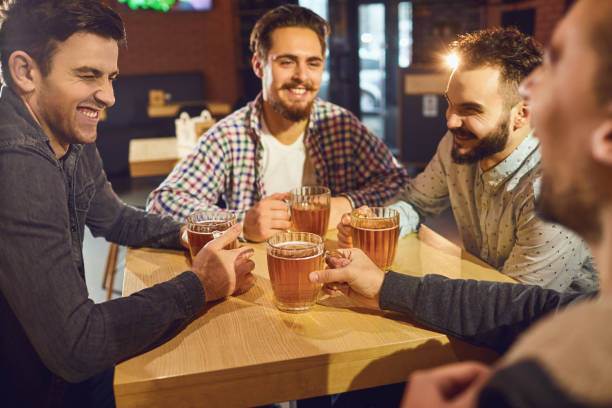 istock Friends talk, drink beer in a bar. 1175853561