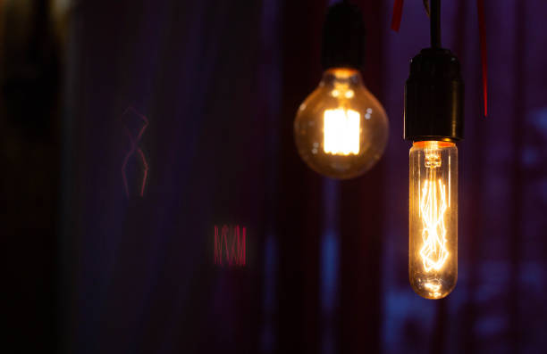 Two filament lamps hang in a cafe, copy space