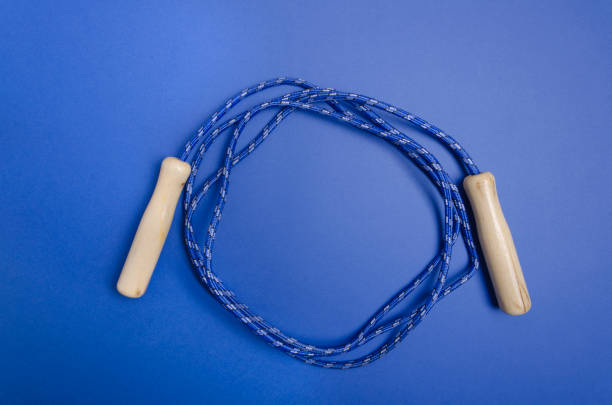 Skipping rope on the dark blue backgroundactivity, aerobics, athletics, blue, childhood.Empty space for design
