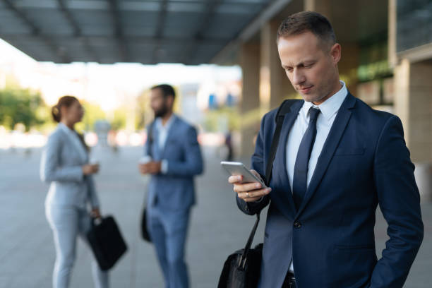 istock Young businessman reading text message on mobile phone outdoors 1175862682