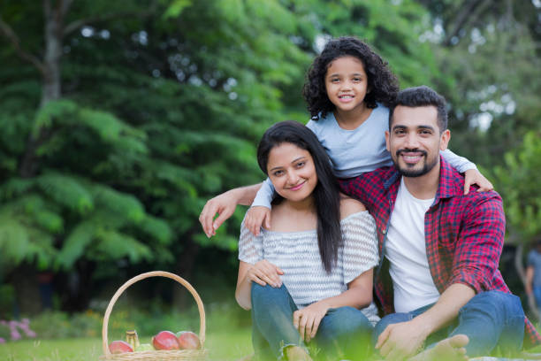 Family enjoying summer picnic in the nature stock photo Picnic, Family, Springtime, Child, Parent happy indian young family couple stock pictures, royalty-free photos & images