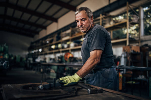 istock Senior man working in metal factory 1175865357