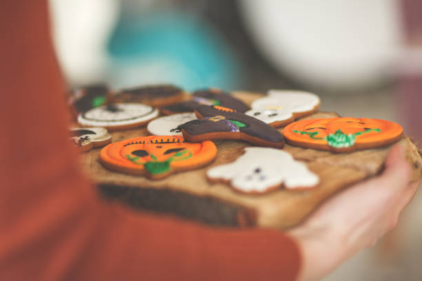 istock Girl holding cutting board with Halloween cookies 1175865590