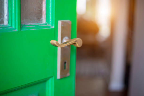 istock Ajar green door with brass handle 1175866956