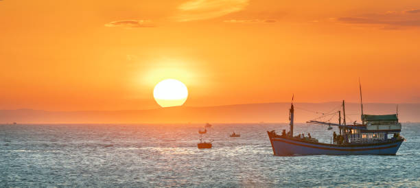 sea landscape at sunset when fishing boats out to sea to harvest fish end the day. - day to sunset imagens e fotografias de stock